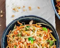 Crunchy Thai Peanut Salad with shredded rainbow cabbage, edamame, and creamy peanut dressing".